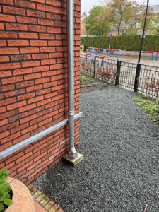 Drainwell onder de regenpijp, hemelwater schoon de grond in